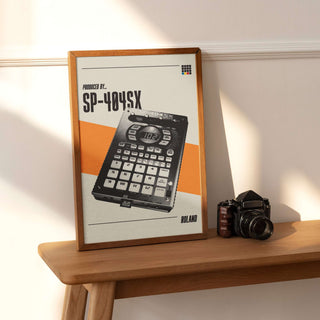 Roland SP-404SX sampler poster on matte paper, framed, on a wooden surface.