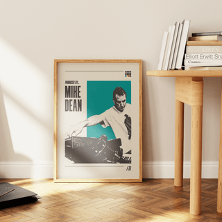 Mike Dean poster in stylish living room setting with wooden floor and books.